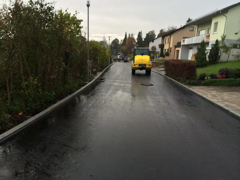 Frisch asphaltierte Ortsstraße nach Abschluss der Straßenbauarbeiten