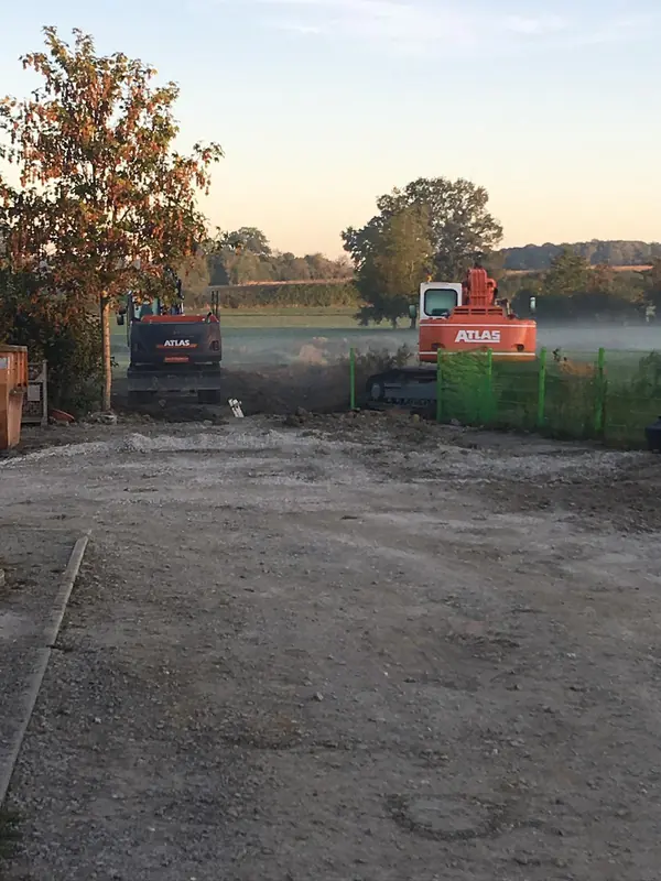 Atlas Bagger und Kipper auf einer Erdbaustelle im Morgennebel