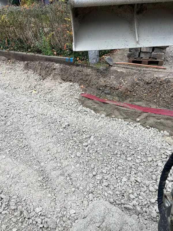 Rotes Kabelschutzrohr verlegt in der frisch profilierten Schottertragschicht