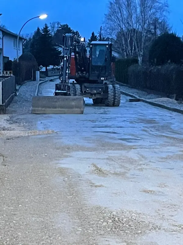 Mobilbagger auf einer im Bau befindlichen Straße bei klarem Winterwetter