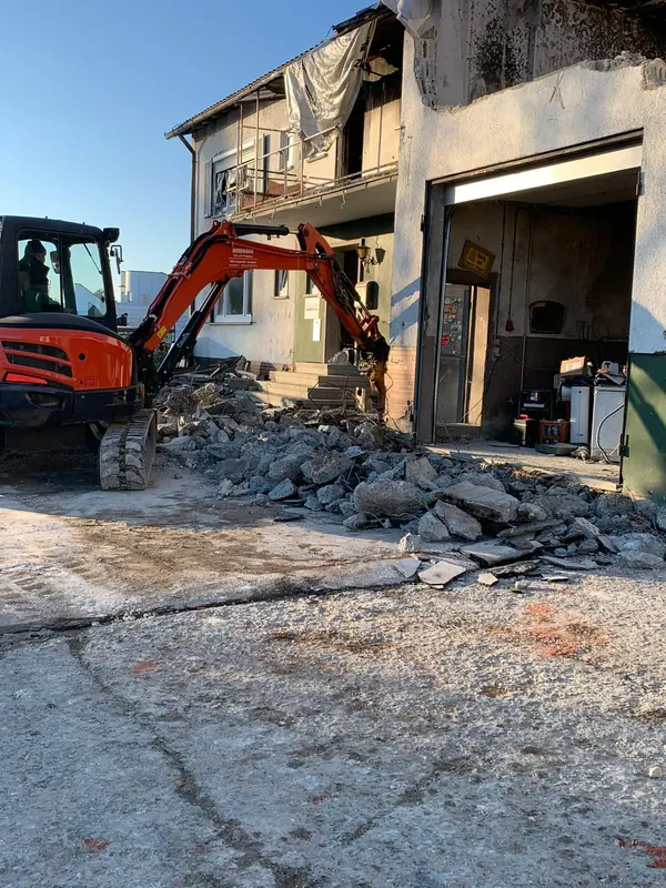 Kubota Minibagger bricht mit dem Hammer einen Betonboden in einem Bestandsgebäude auf