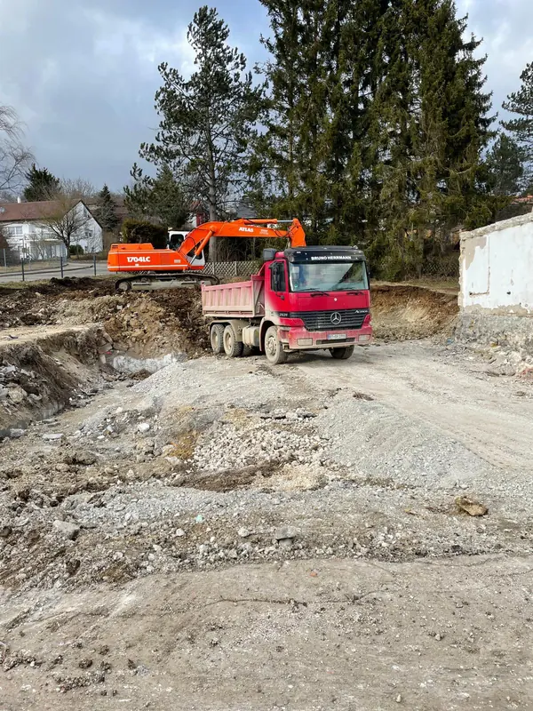 Kettenbagger belädt einen Kipper mit Aushubmaterial auf der Baustelle