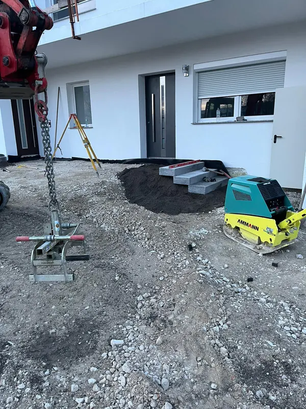 Rüttelplatte und Anbaugerät bei den Außenanlagen an einem neu gebauten Wohnhaus