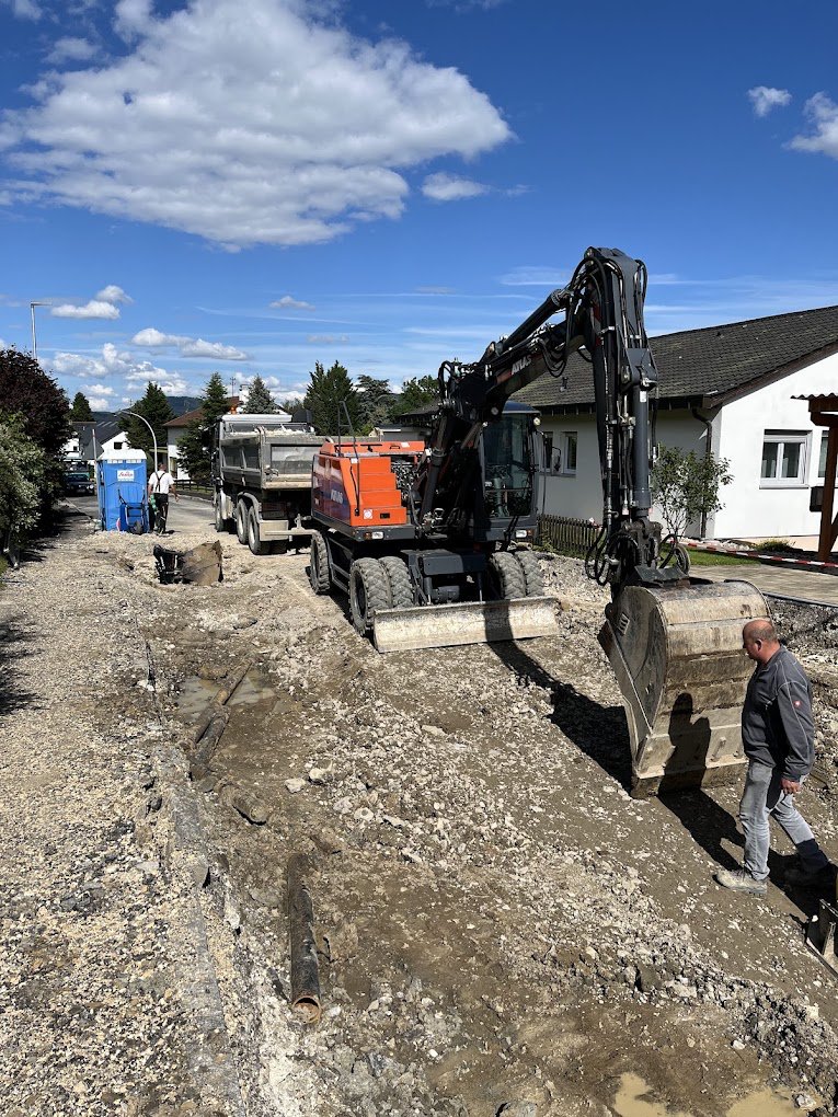Straßenbaustelle mit Bagger und Kipper