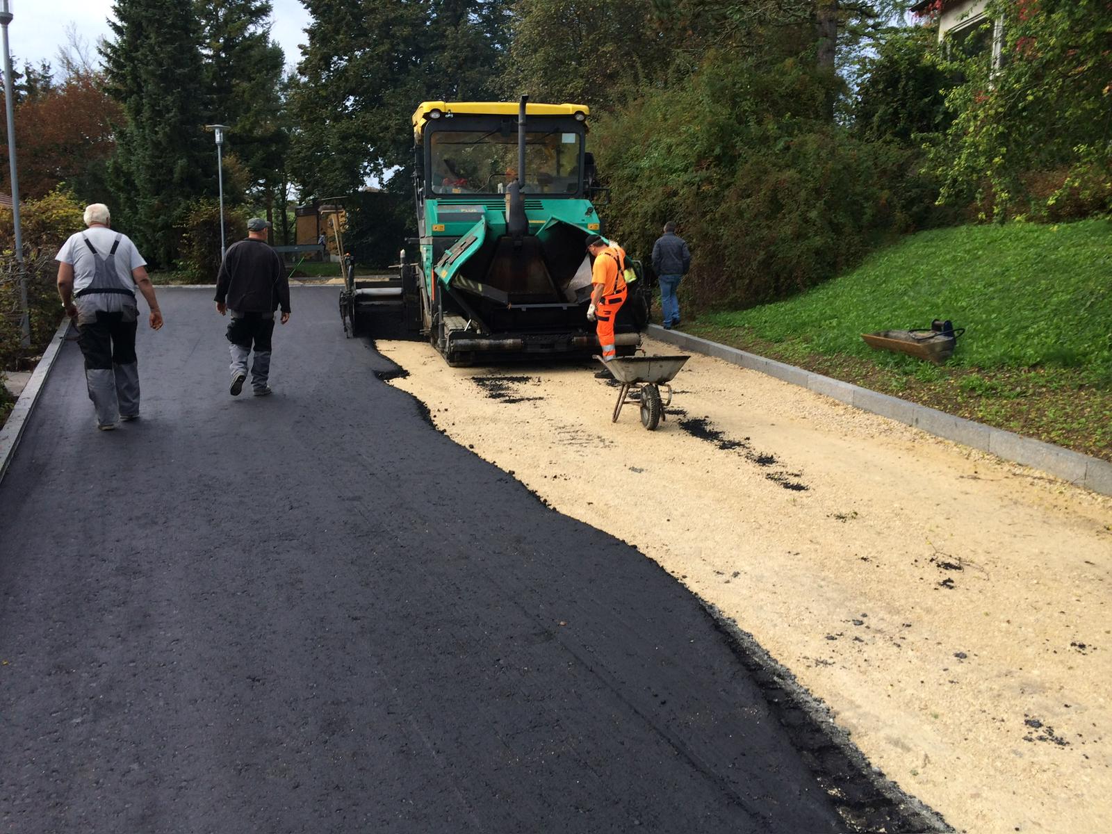 Asphaltfertiger beim Einbau der Deckschicht auf einer Ortsstraße